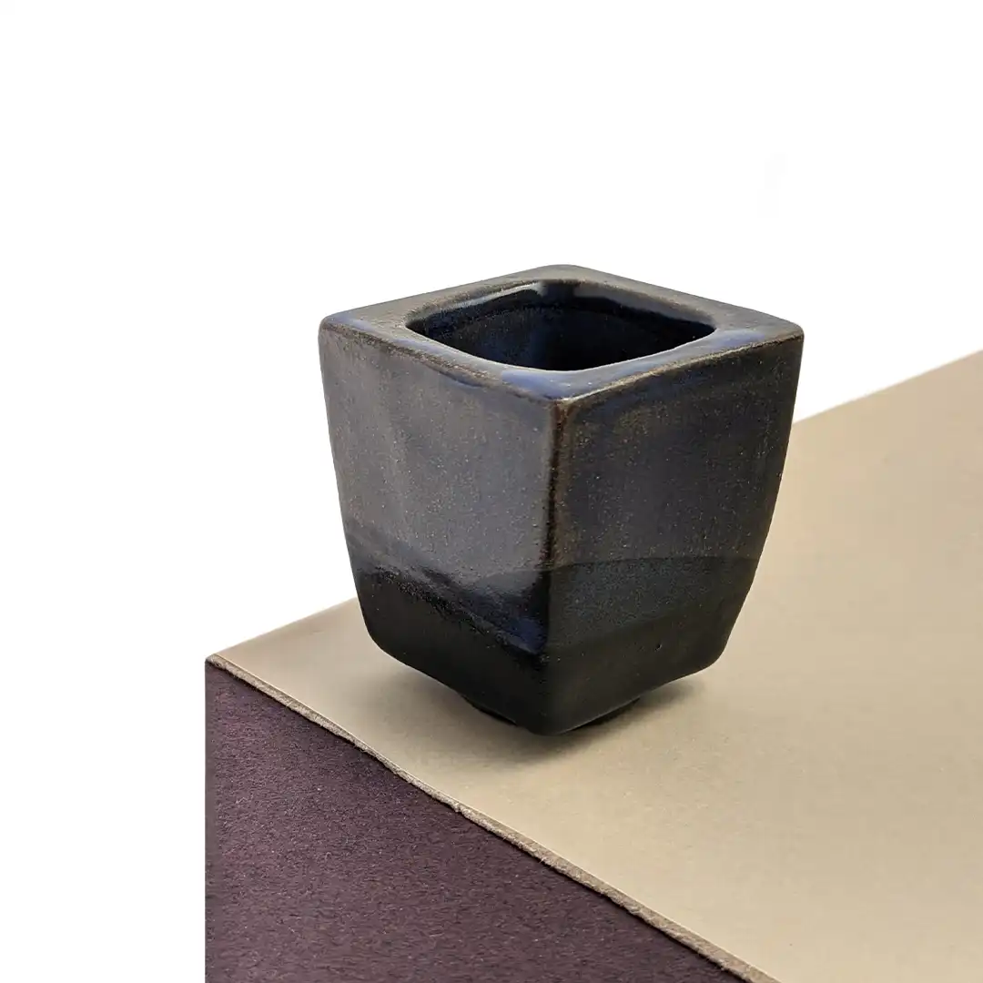 Mini maceta de cerámica para suculenta en tonos azul oscuro.