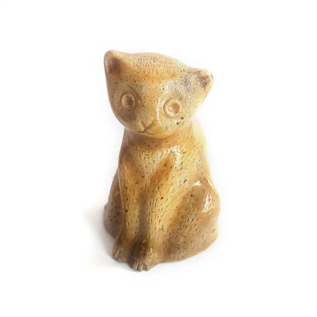 Figura de cerámica en forma de gato amarillo.
